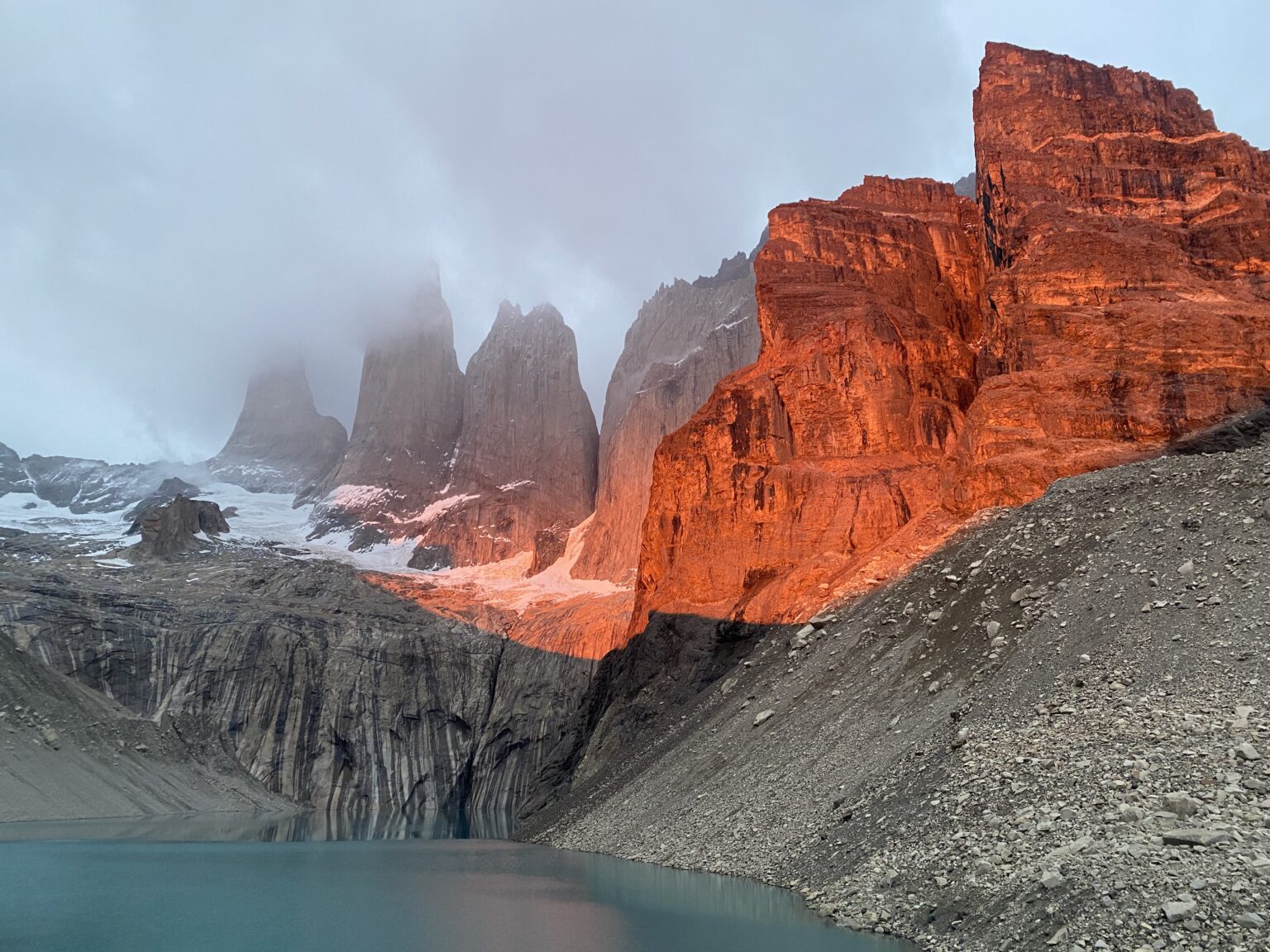 Sonnenaufgang erstrahlt einen Berg in orange, Torres del Paine, Chile.